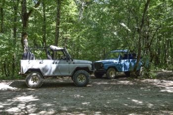 SUV in the forest. Transport for hilly and mountainous terrain. Russian off-road vehicle.. Shapsugskaya, Russia - June 30, 2017: SUV in the forest. Transport for hilly and mountainous terrain. Russian off-road vehicle.