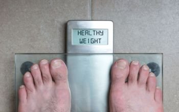 Closeup of man’s feet on weight scale - Healthy weight