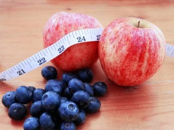 Apple and blueberry with measuring tape concept of healthy diet.