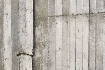 texture of wooden formwork stamped on a raw concrete wall as background  