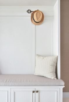 Cozy seat with white frame with striped pillow and panama hat