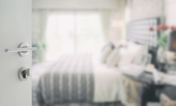 opened white door to blurred background of modern bedroom interior