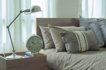 Reading lamp and clock next to japanese style bedding