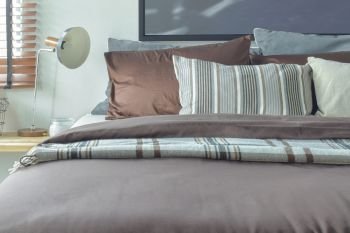 Brown and gray color scheme bedding with reading lamp