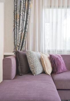 L shape purple sofa with stylish pillows in living room