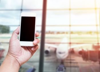 A man hand holding empty screen of smart phone blurred photo airport terminal background with screen clipping path of phone include.