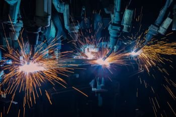 Industrial robots are welding in factory