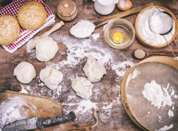 pieces of dough made from wheat flour on a brown table and ingredients