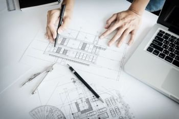 Close-up Of Person’s engineer Hand Drawing Plan On Blue Print with architect equipment