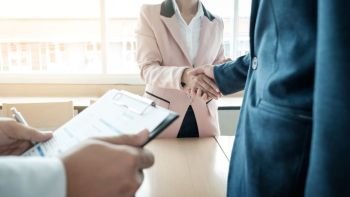 of successful business team shaking hands with eachother in the office, job interview concept.