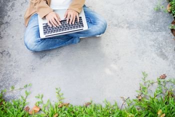 business woman hand using laptop on table in garden