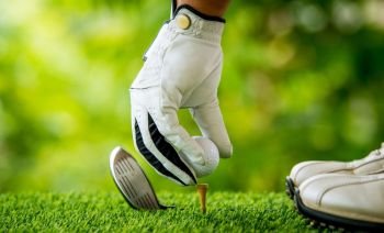 golfer preparing golf ball for teeing off