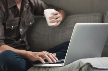 happy man using laptop with coffee