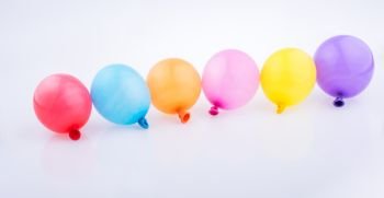 Colorful small balloons in line on a white background
