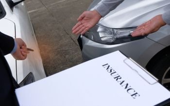 Loss Adjuster Insurance Agent Inspecting Damaged Car 
