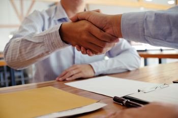 Image business mans handshake after signing contract making a deal. Business partnership meeting concept