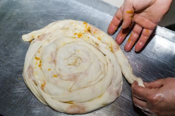 pie dough is rolled, in the tray and woman hands.