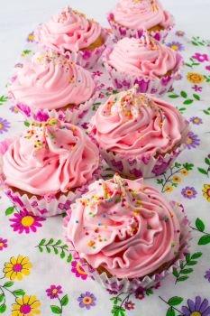 Pink cupcakes  on floral pattern napkin. Pink cupcakes  on floral pattern napkin. Homemade cupcake. Sweet dessert. Sweet pastry.  Gourmet cupcakes. Sweet cupcake. Birthday cupcakes. 
