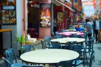 Street restaurant in Chinatown of Singapore. Focus on a table in the foreground