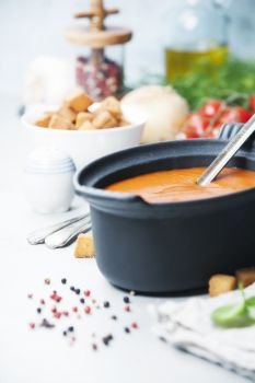 Homemade tomato cream soup in bowls  (or gazpacho) over concrete background