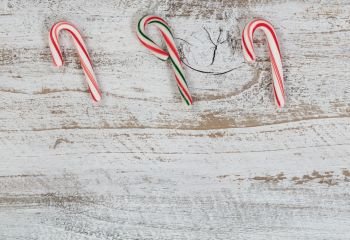 Small candy canes on rustic wood for Christmas concept 