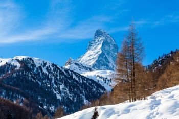 Scenic view on snowy Matterhorn peak in sunny day with blue sky.  Switzerland
