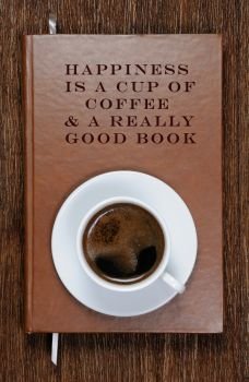 HAPPINESS  IS A CUP OF  COFFEE & A REALLY  GOOD BOOK . A book with a motivational quote and a cup of coffee