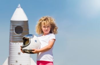 Portrait of blonde little girl in an astronaut costume with toy rocket dreaming of becoming a spacemen. Portrait of blonde little girl in an astronaut costume with toy rocket dreaming of becoming a spacemen.