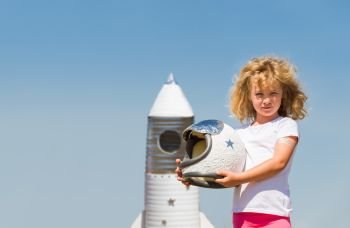 Portrait of blonde little girl in an astronaut costume with toy rocket dreaming of becoming a spacemen. Portrait of blonde little girl in an astronaut costume with toy rocket dreaming of becoming a spacemen.