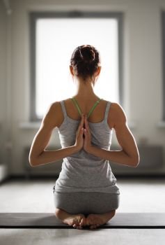 Relaxed young sportswoman doing yoga and meditating in studio. Relaxed young sportswoman doing yoga and meditating in studio.