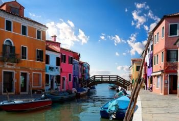 View on colored houses and water canal in the street of Burano, Italy. Sunny day in Burano