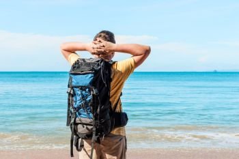 vacation with a sea view - a tourist with a backpack admires the sea
