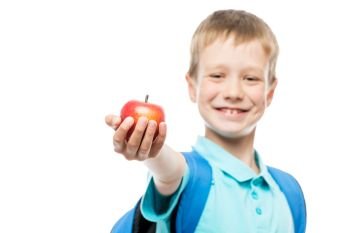 apple in focus in schoolboy’s hand close-up