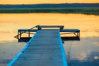 original wooden pier near a calm lake at dawn