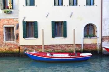 Boat near house on narrow canal in Venice, italy
