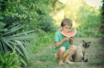 Young boy eating watermelon outdoors