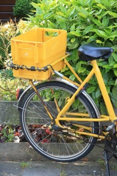 Yellow bike with a container, used to transport the daily mail and small packages