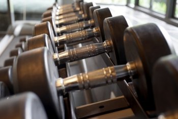 lifting weight, rows of sports dumbbells in the gym