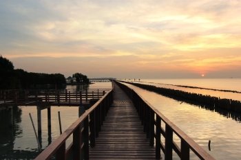 wooden jetty on seaside with beautiful sunrise background