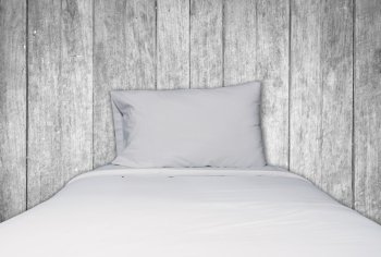 Close up white bedding and pillow on black and white wooden texture background, stock photo