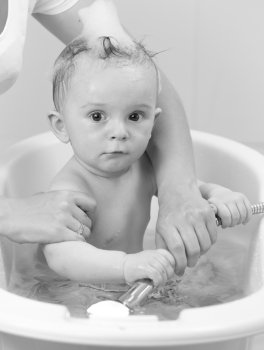 Black and white portrait of cute baby boy having bath time