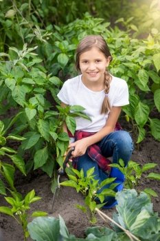 Portrait of happy young woman working at garden with trowel