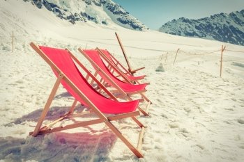 View of Empty red beds on the snow, relaxing concept, with vintage effect