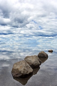 Serene balance of rocks leads gaze to the sky and clouds.  Location is Lewis Lake in Yellowstone National Park in Wyoming. 