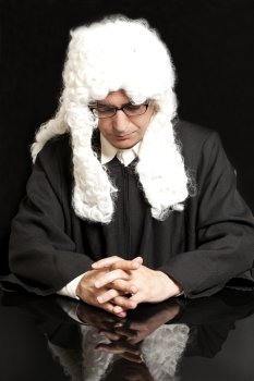 Portrait Of Male Lawyer  in a wig with eyeglasses on black background