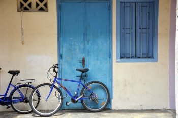 Bicycle leaning against a white painted brick wall