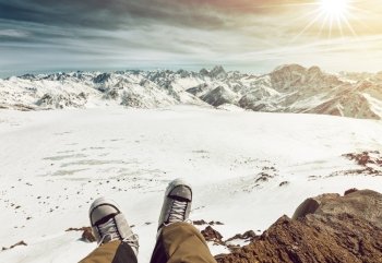 Feet selfie of snowboarder resting and enjoying the view of mountains. Elbrus, the northern Caucasus mountains, Russia