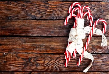 candycanes with white ribbon on the wooden table