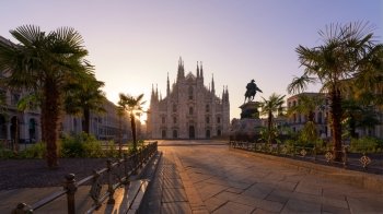 Duomo square with new exotic palms tree , Milan gothic cathedral at sunrise,Europe.