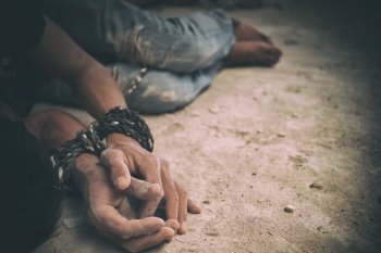 hopeless man hands tied together with rope, human trafficking